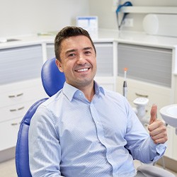 Male dental patient giving a thumbs up