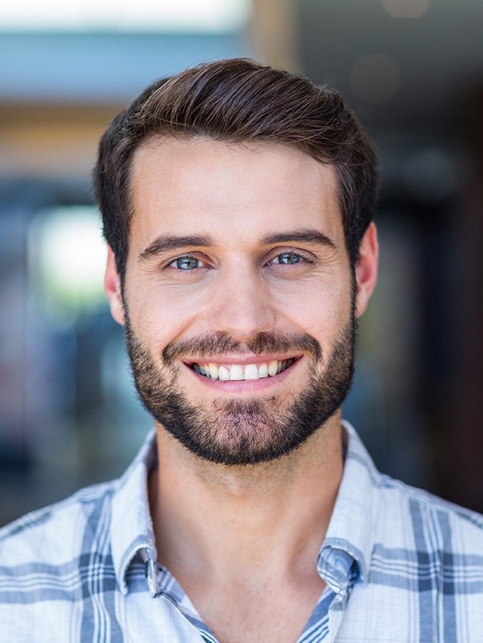 Man with beard standing and smiling