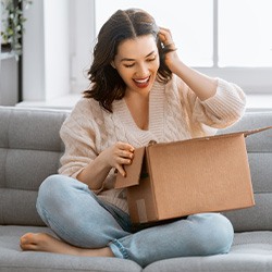 Woman sitting on couch and looking in a box