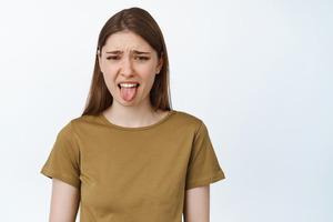 Woman sticking out tongue because of bad taste