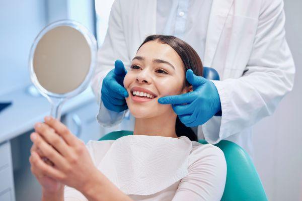 woman sitting in dentist exam chair smiling | cosmetic dentist cary