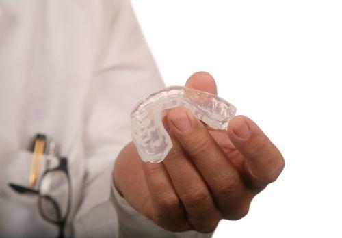 patient holding clear plastic aligner | snoring treatment cary